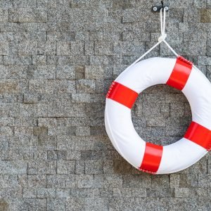 Life ring hang on stone wall around swimming pool